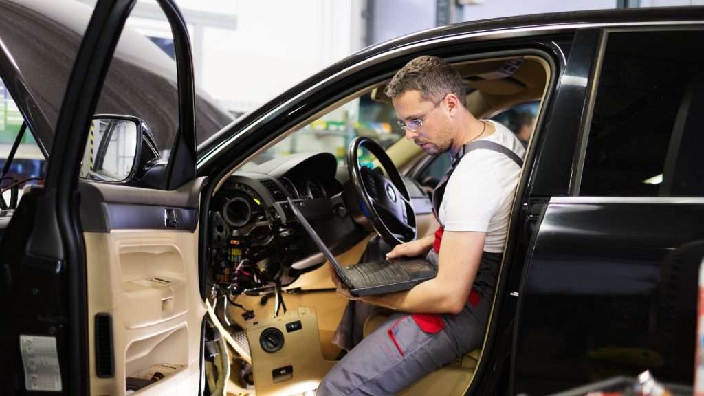 A professional car locksmith working inside a vehicle