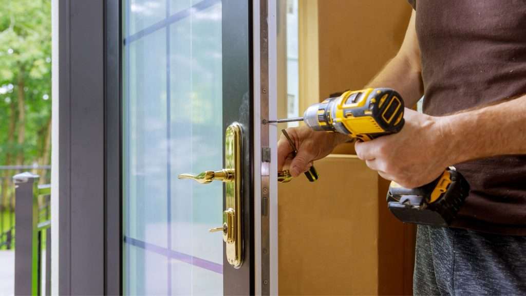 A commercial locksmith installing a new door handleset