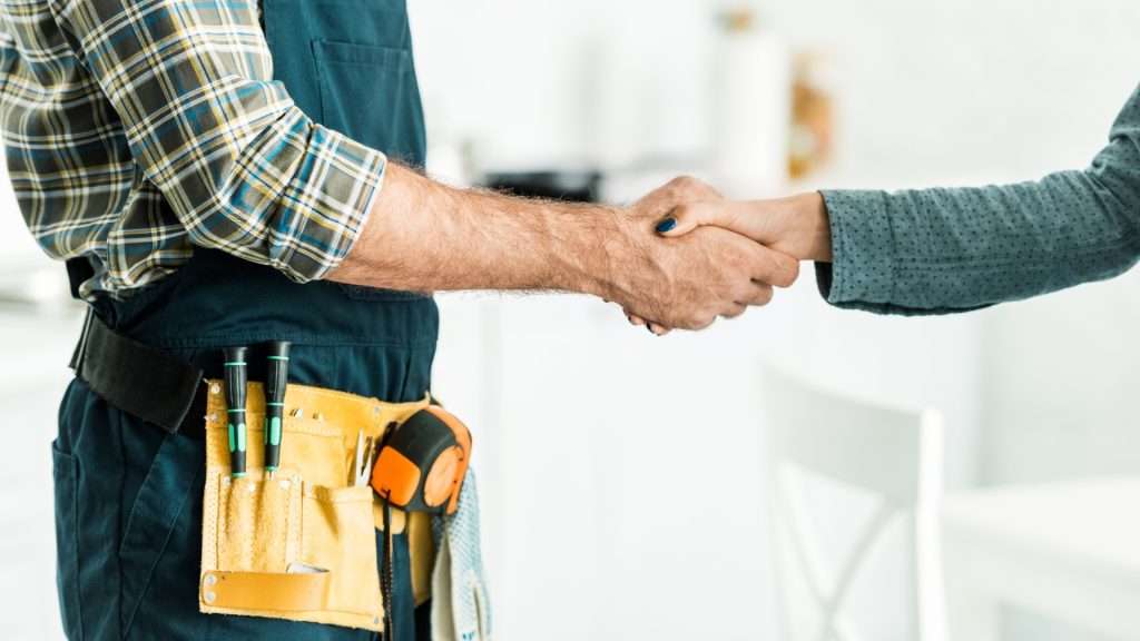 A residential locksmith shaking hands with a satisfied client