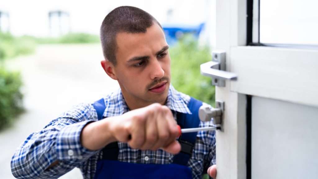 A locksmith installing a lever handle door lock.