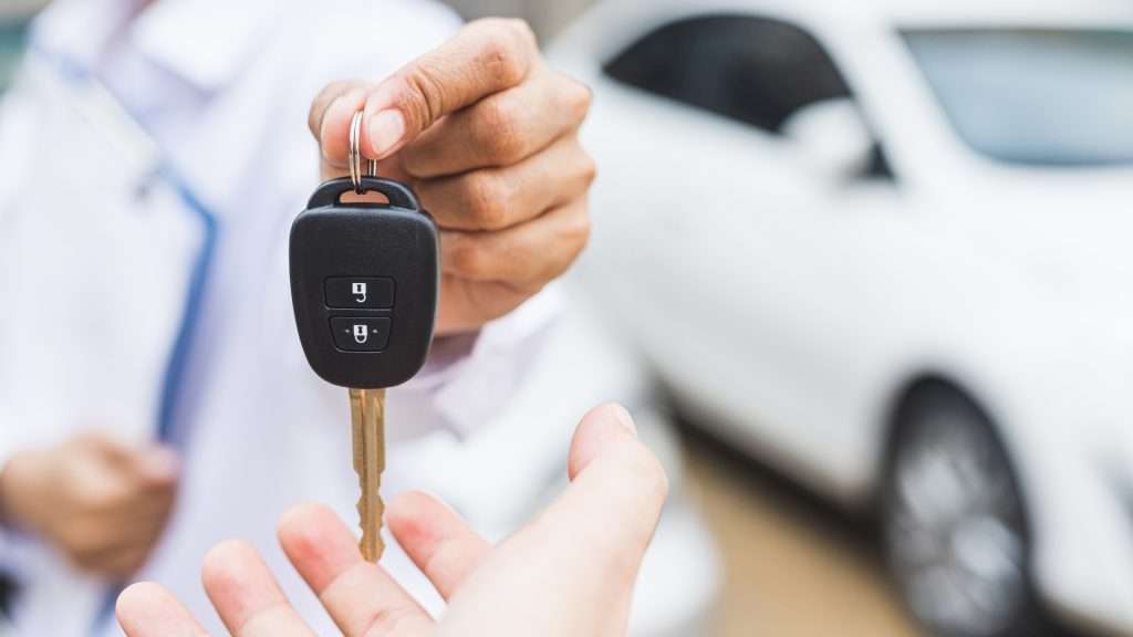 A car owner being handed a spare car key