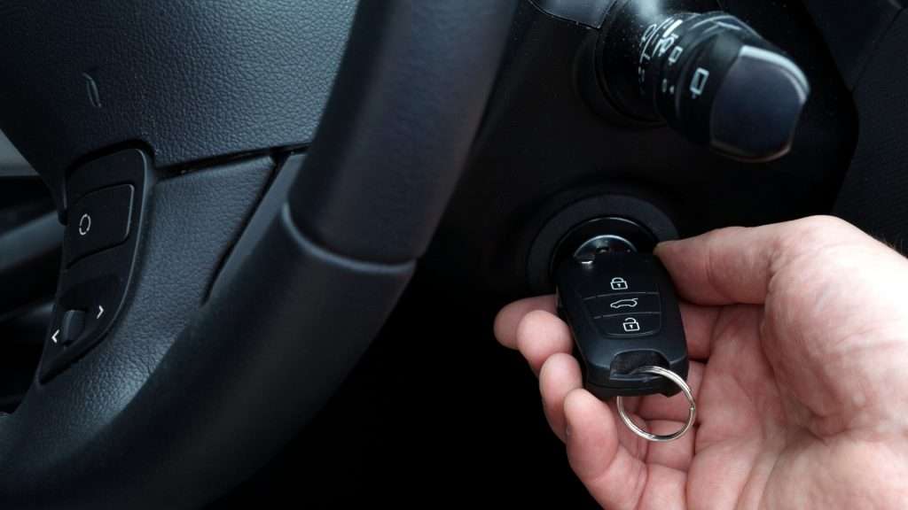 A user inserting the car key into the ignition