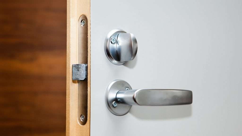 A lever-style residential door lock in chrome finish