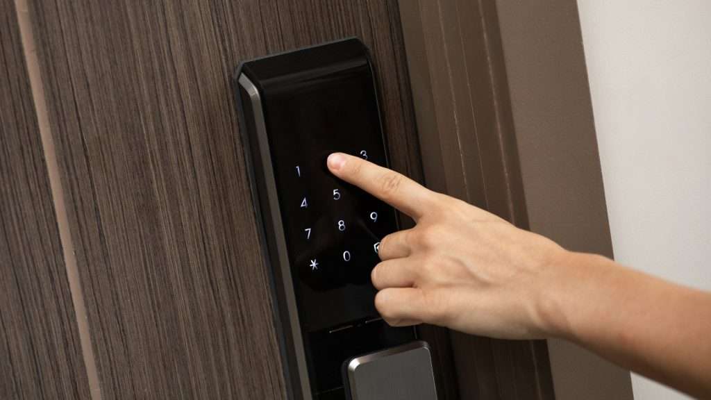 A user entering a code into a smart door lock