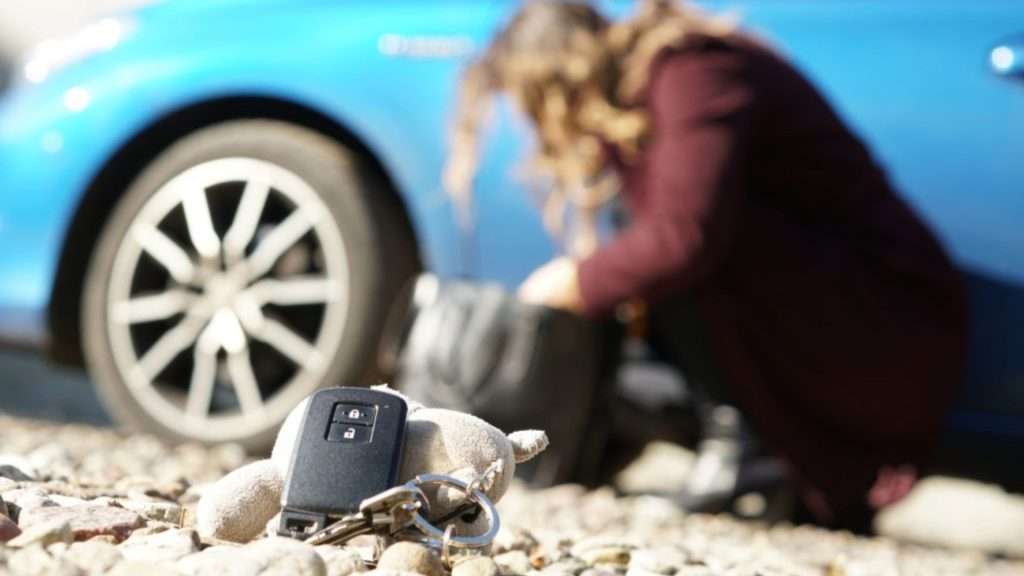 A driver searching her bag for her car key. In the foreground was the dropped car key