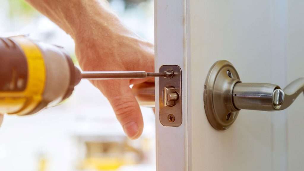 A locksmith installing a lever door lock