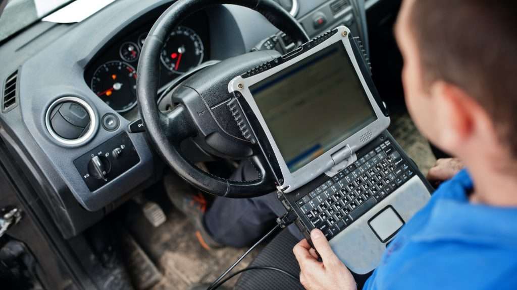 A locksmith performing transponder key programming on a vehicle
