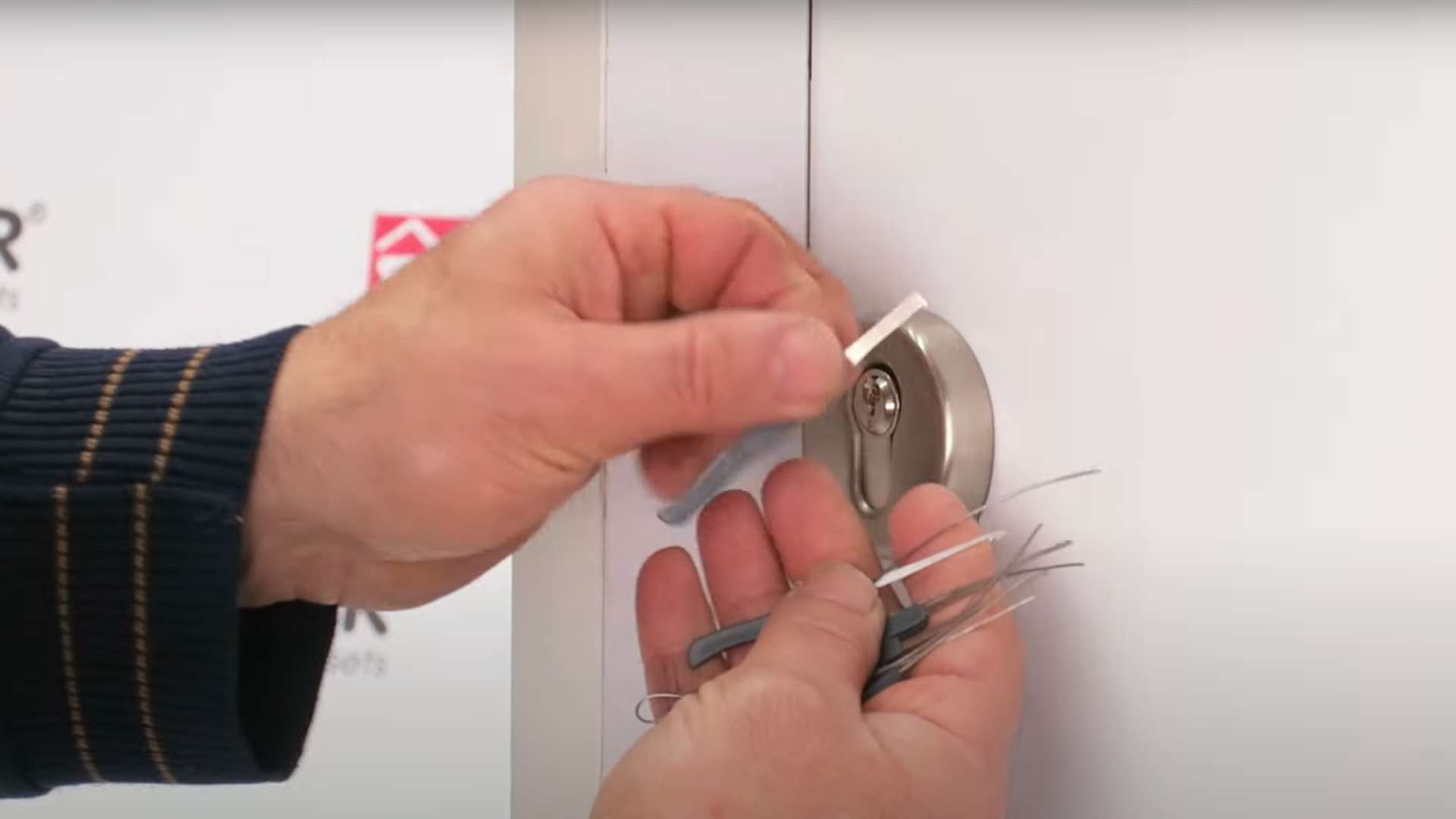 A locksmith choosing the right picking tool during a broken key extraction