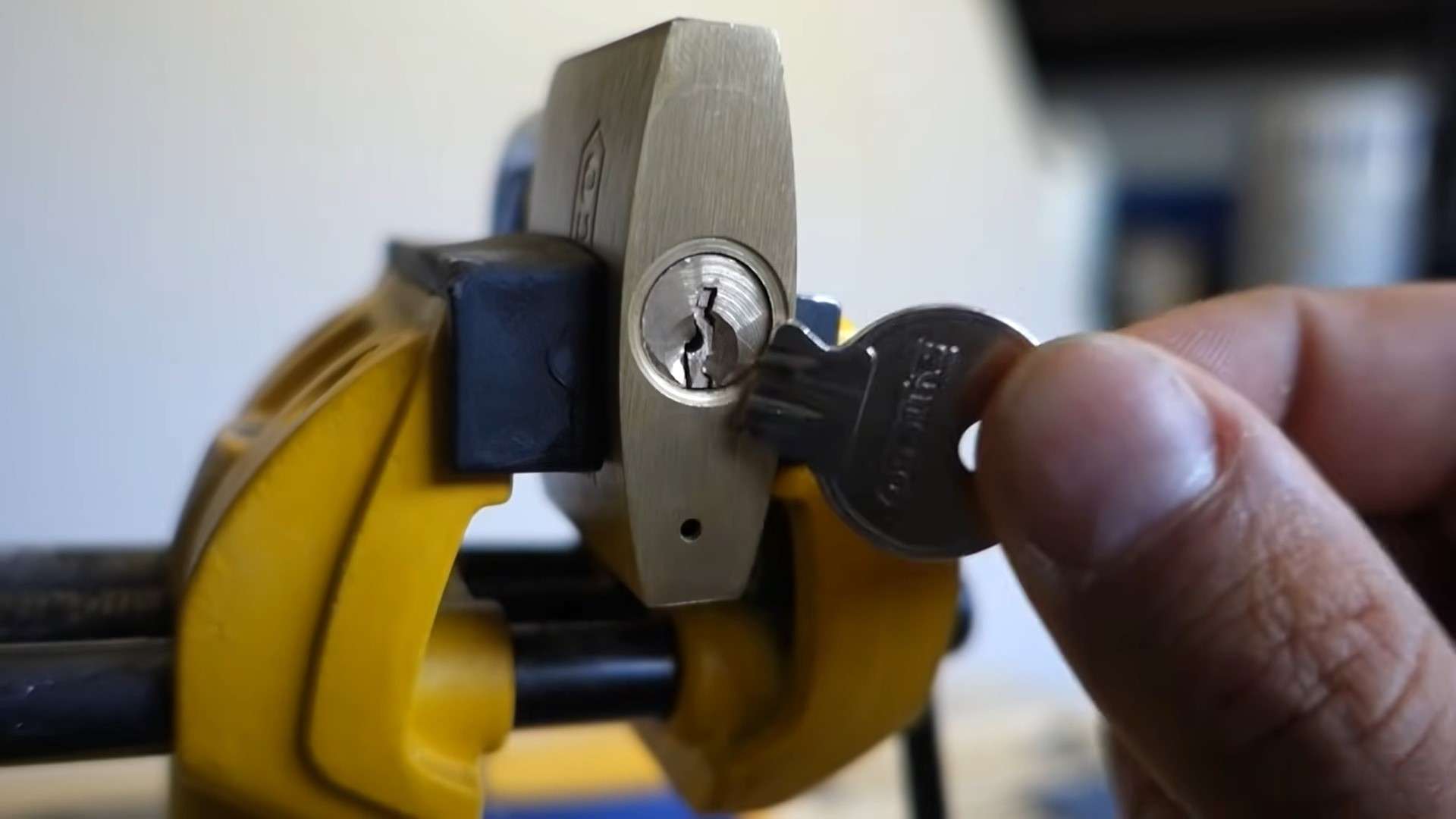 A locksmith doing a broken key extraction on a padlock