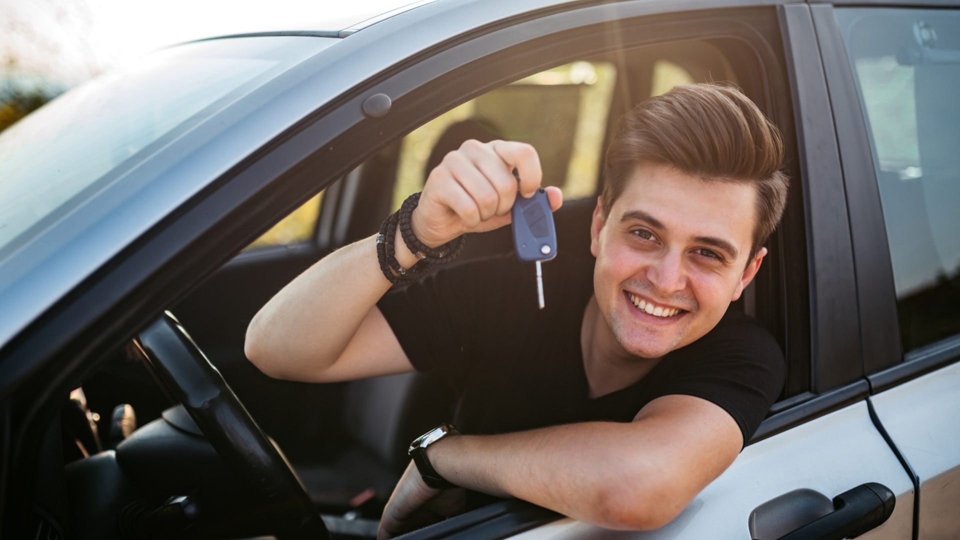 The car owner regains car access, holding up his car keys and showing successful car door unlock services.